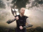 Battlelore-bändin kitaristi Jyri Vahvanen pitää kirvestä kädessään. Taustalla pilvinen taivas.