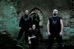 Thus Defiled -bändin promokuva. Neljä miestä seisoo ränsistyneen holvikaaren edessä.