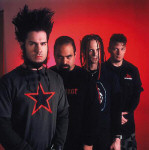 Static-X -bändin promokuva. Miehet seisovat punaista taustaa vasten. Kuvassa neljä miestä, joista yhdellä rastat ja toisella hiukset pystyssä.