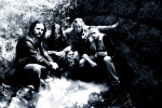 Wolf-bändin promokuva. Miehet istuvat mustavalkoisessa kuvassa lähteen ääressä, yhdellä miehistä on käsissään pääkallo.