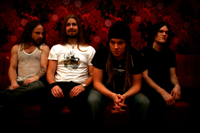 Memfis-bändin pressivalokuva vuonna 2008. Yhtyeen miehistö, johon kuuluu neljä nuorehkoa hevimiestä, istuvat rivissä koristeellista verenpunaista taustatapettai vasten tummalla sohvalla. Kaikilla jampoilla pitkät hiukset ja lyhythihaiset paidat. Vasemmanp