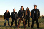 Morgana Lefay -bändin jäsenet seisovat pellolla sinisen taivaan alla. Kuvassa viisi miestä, jotka seisovat rivissä.