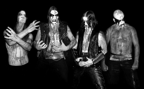 Ragnarok-bändin jäsenet mustavalkoisessa kuvassa mustaa taustaa vasten. Miehillä corpse-maskit ja veriset rinnukset. Kasvoilla yrmy ilme. Niittivöitä ja -rannekkeita.