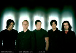 Nine Inch Nails -bändin jäsenet seisovat rivissä. Kuvassa viisi miestä, joista jokaisella mustat vaatteet ja lyhyet hiukset.