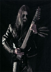 Dark Funeral -bändin Lord Ahriman seisoo kitara kädessään mustaa taustaa vasten. Miehellä on käsivarsissaan niittirannekkeet ja yllään musta nahkatakki ja -housut. Kasvoilla corpse-maskit.