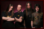 Koma-bändin promokuva, jossa neljä miestä seisovat purppuranväristä taustaa vasten. Kahdella miehistä on pitkät hiukset.