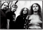 Mustavalkoinen bändikuva Napalm Death -yhtyeen jäsenistä. Kuvassa neljä miestä, joista kahdella on pitkät hiukset. Vasemmassa laidassa näkyvällä miehellä on partaa.