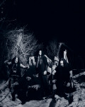 Finntroll-bändin jäsenet poseeraavat lumihangessa pimeänä talvi-iltana tai -yönä. Yhdellä miehistä on musta silinterihattu päässään.