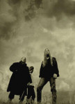 Negura Bunget -bändin kolme jäsentä vanhanaikaisessa valokuvassa, joka on mustavalkoinen. Miehet seisovat pilvisen taivaan alla.