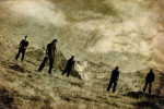Mustavalkoinen kuva Dawnless-yhtyeen jäsenistä, jotka seisovat vuorisessa maastossa. Taivaalla näkyy jonkin verran pilviä. Maassa on vain ruohoa, ei puita tai pensaita. Kuvassa näkyy viiden miehen hahmot.