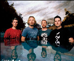 Nickelback-bändin jäsenet seisovat peilikirkkaassa vedessä, josta näkee miesten heijastukset. Kuvassa neljä miestä, joista vasemmalla seisoo punapaitainen mies, hänen oikealla puolellaan sinipaitainen. Kaksi oikeanpuoleista miestä pitävät yllään tummia pa