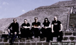 Paradise Lost -yhtyeen jäsenet istuvat kivisen muurin päällä. Kuvassa viisi miestä, joista jokaisella mustat vaatteet yllään. Neljällä oikeanpuoleisella t-paidat ja vasemmanpuoleisella pitkähihainen paita. Taustalla hiekkakasoja.