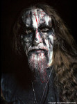 Gorgoroth-bändin Gaahlin kasvopotretti, jossa mies on mustaa taustaa vasten. Kasvot on maalattu mustalla ja valkoisella ja verellä. Miehellä on viiket sekä parta + pitkät hiukset. Kaulassa jonkinlainen ketju tai riipus.