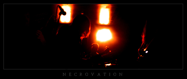 Synkkä bändikuva Necrovation-yhtyeen jäsenistä keltaisten valojen edessä ja mustaa taustaa vasten.