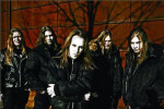 Children Of Bodom -bändin jäsenet. Taustalla punainen seinä, jossa puun varjoja. Etualalla bändin jäsenet, joista jokaisella pitkät hiukset.