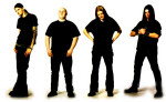 Dawn Of Relic -bändin jäsenet valkoista taustaa vasten. Miehet ovat pukeutuneet mustiin vaatteisiin.