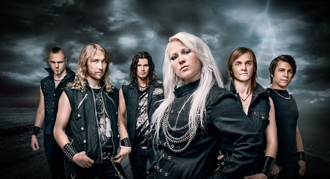 Kuvassa helsinkiläinen power metal -yhtye Battle Beast. Kuvassa keskimmäisenä yhtyeen uusi vokalisti Noora Louhimo. Ryhmäuva Battle Beastin kokoonpanosta, johon kuuluu vaaleahiuksinen nainen etualalla ja viisi mustiin pukeutunutta miestä taka-alalla. Taustalla salamoiva myrskytaivas.