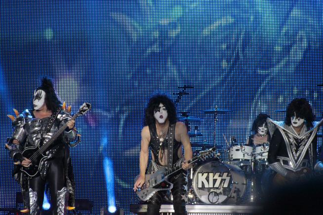 Kuvassa Kiss-yhtye esiintymässä suuren screenin edessä.
