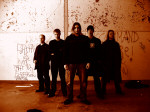 Withering-bändin promokuva, jossa miehet seisovat valkoista seinää vasten. Seinä on sotkettu graffitein. Kuvassa myös bändistä erotettu laulaja ja basisti.
