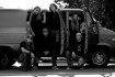 Omnium Gatherum -bändin mustavalkoinen promokuva, jossa miehet ovat Chevy-merkkisen auton edessä.